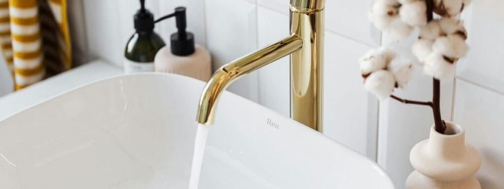 Bathroom sink with gold faucet and trendy decor