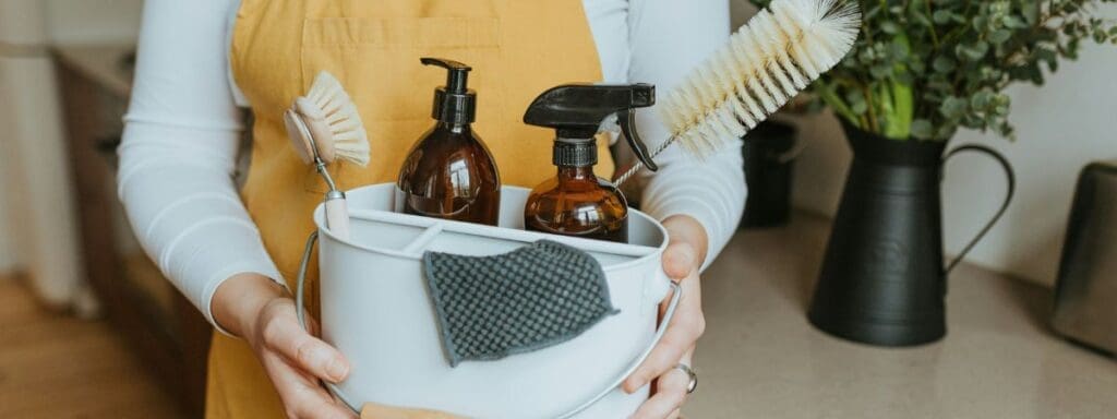 A white tub of natural cleaning capsule products held by a woman in the background