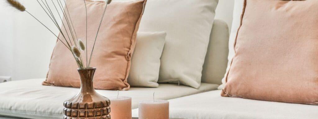Close up of white couch with pink pillows